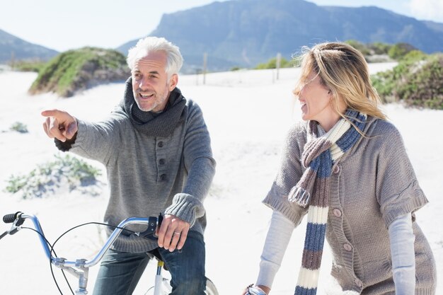 Sorglose Paare, die auf eine Fahrradfahrt und ein Picknick auf dem Strand gehen