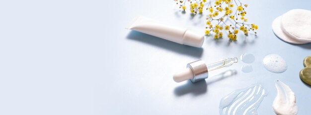 Soro em conta-gotas e creme cosmético de manchas hidratantes com massageador facial em fundo colorido Vista superior