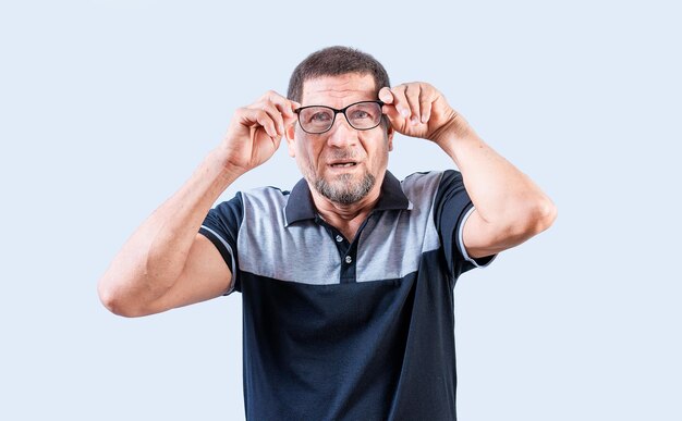 Sorprendido anciano quitando las gafas mirando a la cámara Asombrado anciano quitándose las gafas aislado