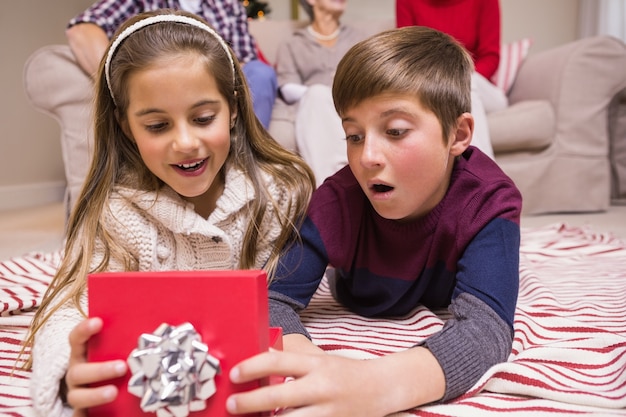 Sorprendido hermano y hermana mintiendo abriendo el regalo