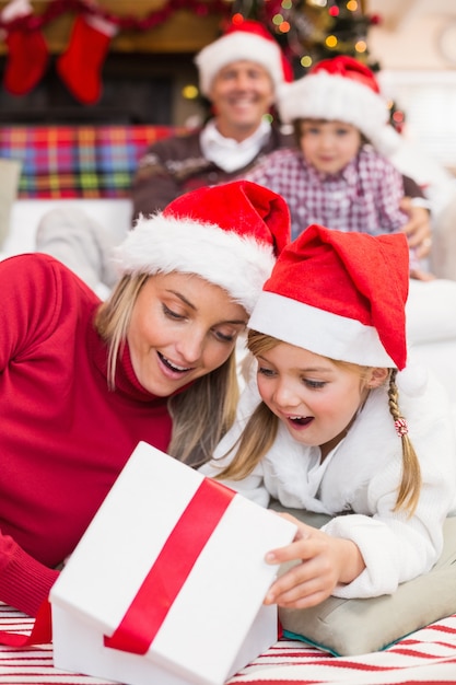 Sorprendido madre e hija abriendo un regalo de Navidad