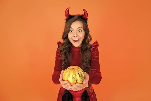 Sorprendido niño diablo de halloween en cuernos de diablillo sostener calabaza para jack o linterna enfoque selectivo feliz halloween