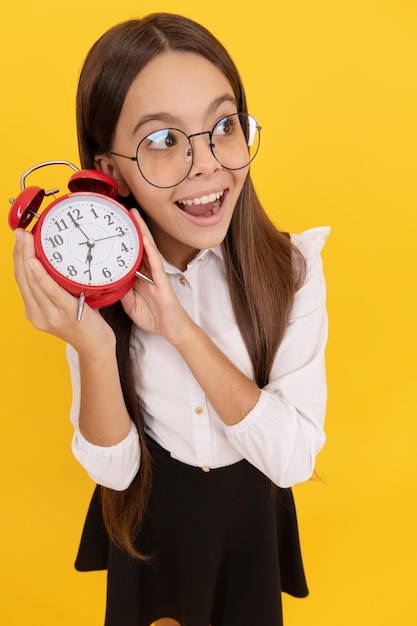 Sorprendido niño nerd escucha el despertador sonando niño de la escuela en uniforme y anteojos mostrando la hora que llegas tarde fecha límite buenos días puntualidad última oportunidad niña adolescente puntual revisando el tiempo