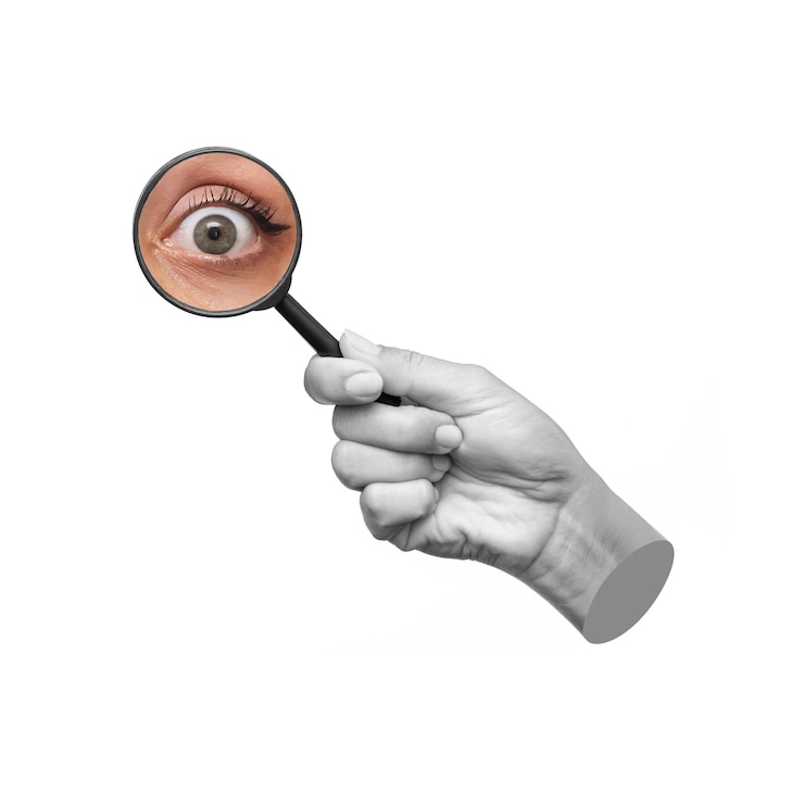 Foto sorprendido el ojo de una joven agrandado con lupa aislado en un fondo blanco