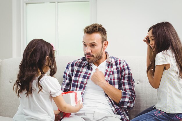 Sorprendido padre mirando a su hija con un regalo