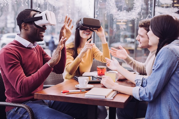 Sorprendió a dos amigos entusiastas sentados con auriculares VR mientras se reían y pasaban tiempo con amigos