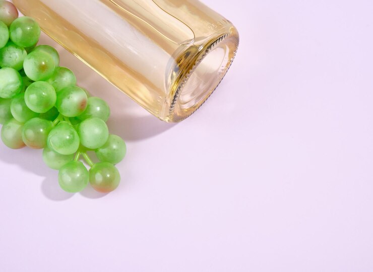 Foto sorpresa romántica un racimo verde maduro de uvas y una botella de vino blanco dulce sobre un fondo púrpura copiar espacio para texto