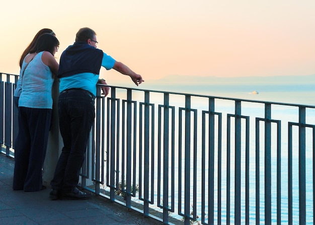 Sorrento, Italia - 2 de octubre de 2017: Gente mirando la puesta de sol en el terraplén de Marina Grande en Sorrento, mar Tirreno, costa de Amalfi, Italia, otoño