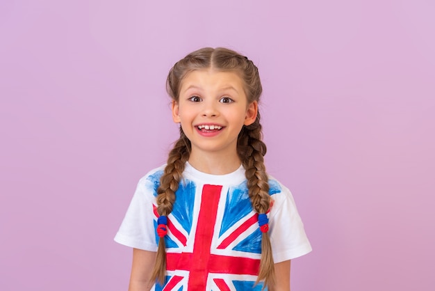 Foto sorri uma menina linda com rabo de cavalo em uma camiseta com a imagem da bandeira inglesa.