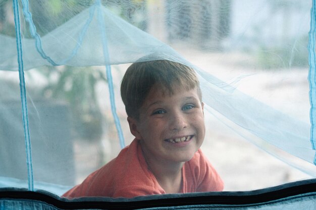 Sorria, criança, menino, deite-se, descanse, rede, com mosquiteiro, Devaneio de infância feliz, Olhe para o retrato risonho