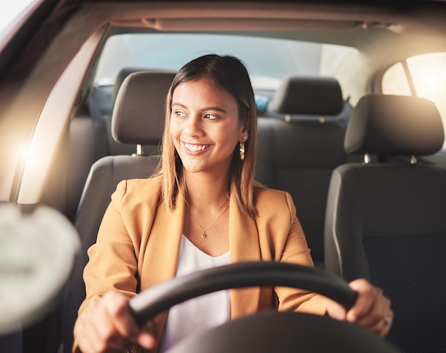 Foto sorria dirigindo e mulher de negócios no carro para viajar ou pensando em transporte na cidade motorista feliz e pessoa em veículo motorizado ou viagem para ir ao trabalho pela manhã