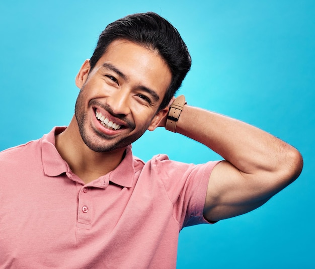 Sorria feliz e o retrato do homem asiático sobre fundo azul com orgulho, confiança e felicidade Moda confiante e rosto de homem isolado no estúdio com estilo relaxante e expressão animada