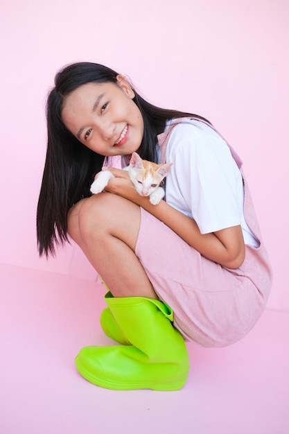 Sorria jovem com gato no fundo rosa