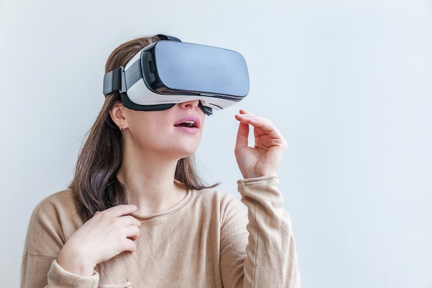 Sorria jovem vestindo usando realidade virtual óculos VR fone de ouvido no fundo branco