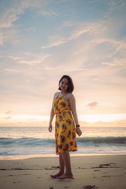 Foto sorria liberdade e felicidade mulher asiática na praia ela está desfrutando da natureza serena do oceano durante a viagem