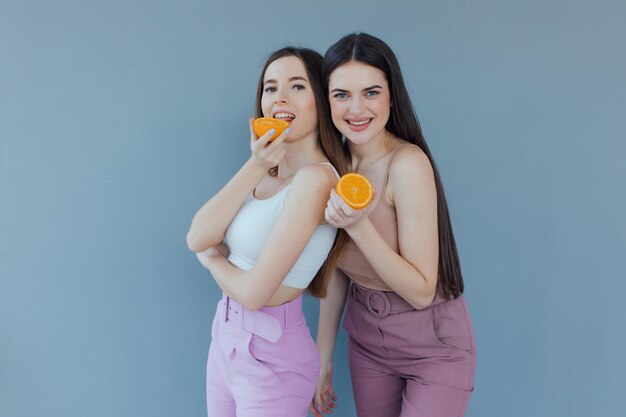 sorria meninas vestindo roupas de verão, elas estão se divertindo e brincando com frutas suculentas