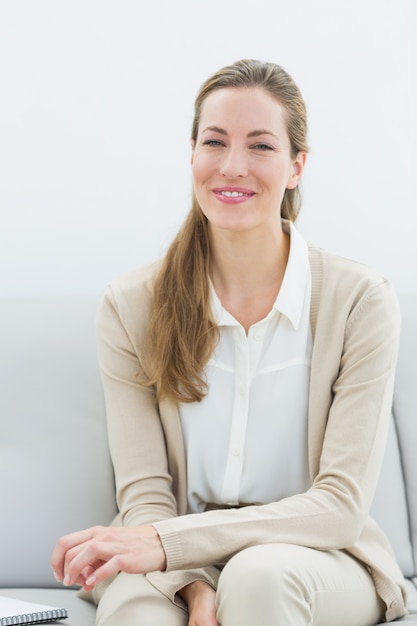 Sorridente consultor financeiro feminino sentado no sofá