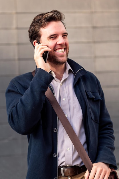 Sorridente empresário caucasiano falando ao telefone