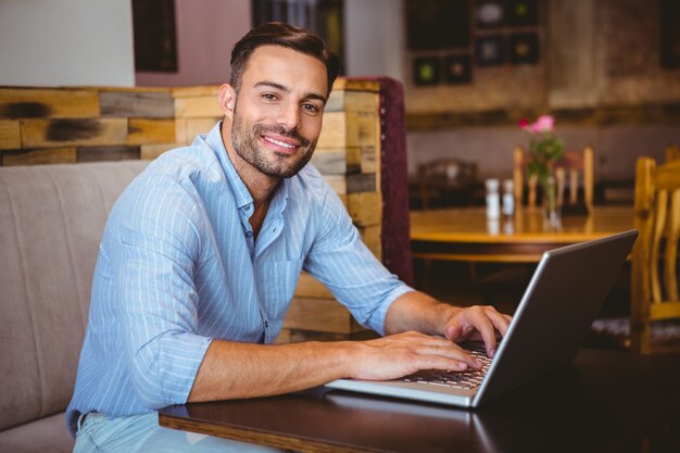 Sorridente empresário usando seu laptop