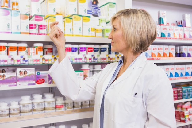 Sorridente farmacêutico olhando remédio
