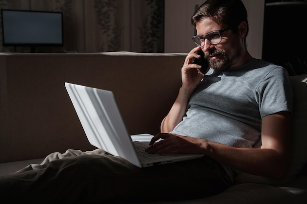 Sorridente freelancer bonito trabalhando remotamente em casa