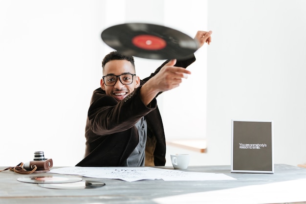 Sorridente homem Africano jogando vinil na câmera