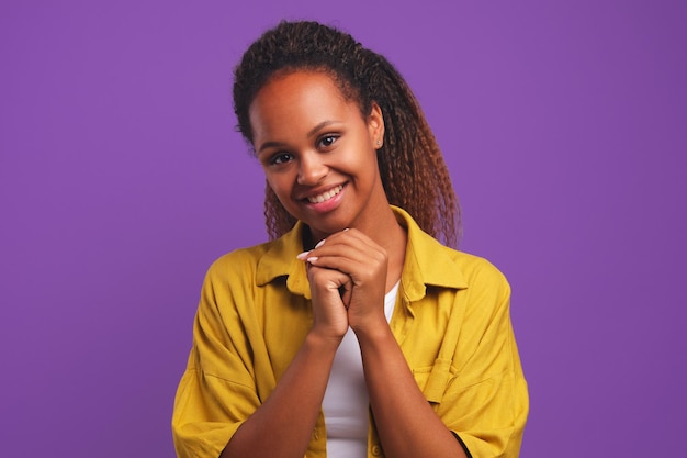 Sorridente jovem afro-americana de mãos dadas no queixo em gratidão