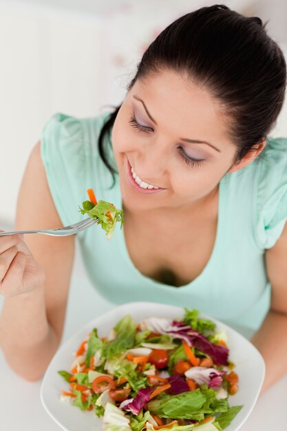 Foto sorridente jovem comendo salada