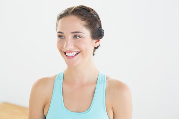 Sorridente jovem em sutiã de esportes azul