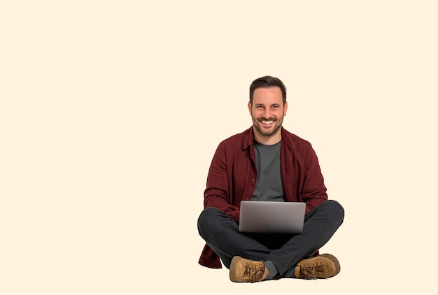 Foto sorridente jovem empresário masculino vestido casualmente analisando estratégias de vendas no laptop