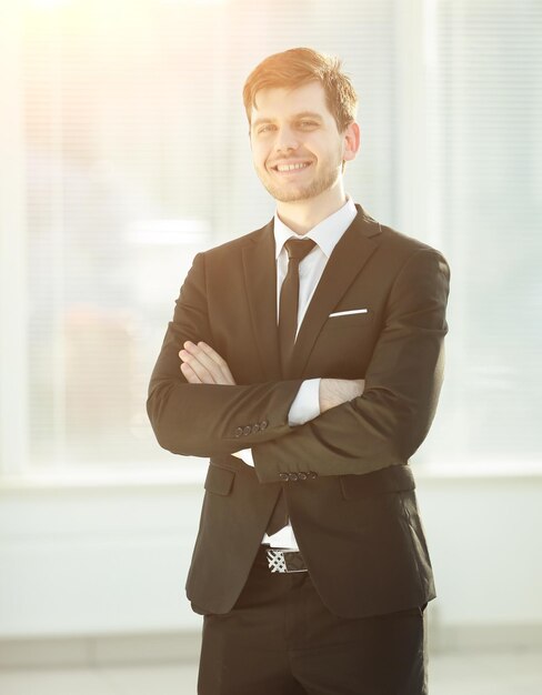 Sorridente jovem empresário no escritório de fundo desfocado