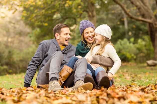 Sorridente jovem família sentada em folhas