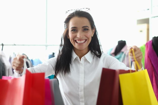 Sorridente jovem feliz com sacolas de compras no shopping