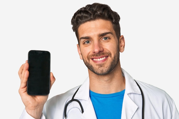 Sorridente jovem médico exibindo seu telefone