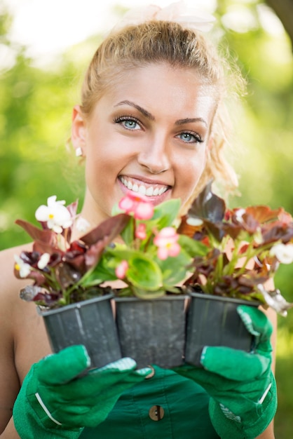 Sorridente jovem plantando flores no jardim.