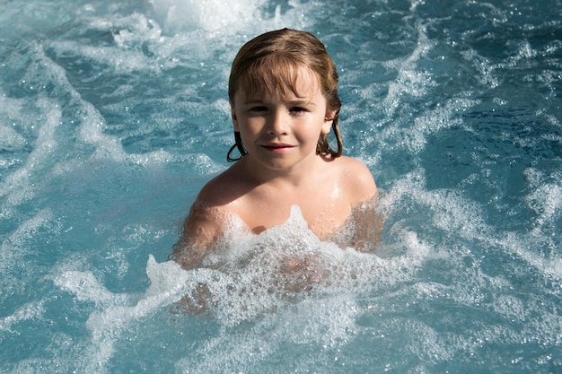 Sorridente menino bonitinho na piscina