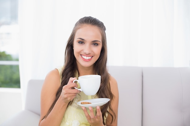 Sorridente morena bonita segurando uma xícara