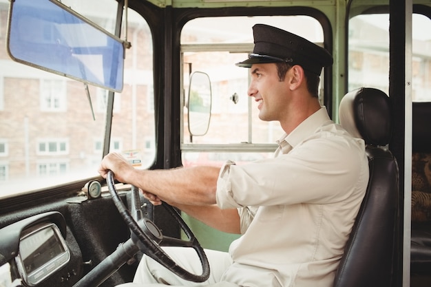 Sorridente motorista dirigindo o ônibus escolar