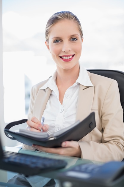 Sorridente, mulher de negócios, segurando, data, livro