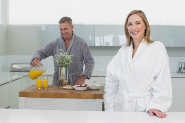 Sorridente, mulher, homem, despejando, suco de laranja, fundo, cozinha