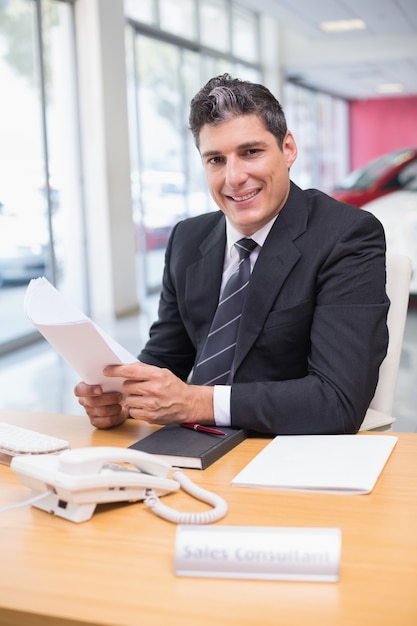 Sorridente vendedor segurando um documento