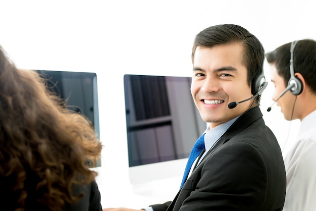 Sorrindo agente de serviço ao cliente de telemarketing masculino em call center