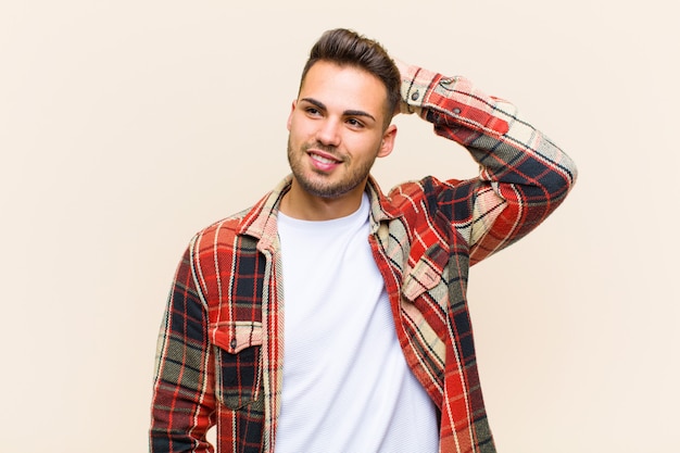 sorrindo alegre e casualmente, levando a mão à cabeça com um olhar positivo, feliz e confiante