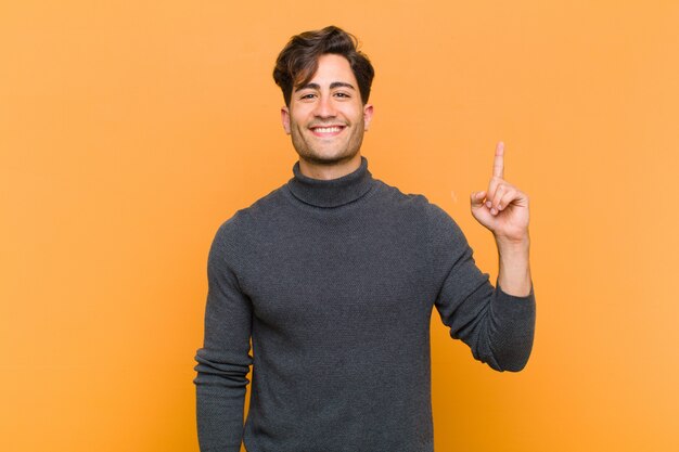 sorrindo alegre e feliz, apontando para cima com uma mão