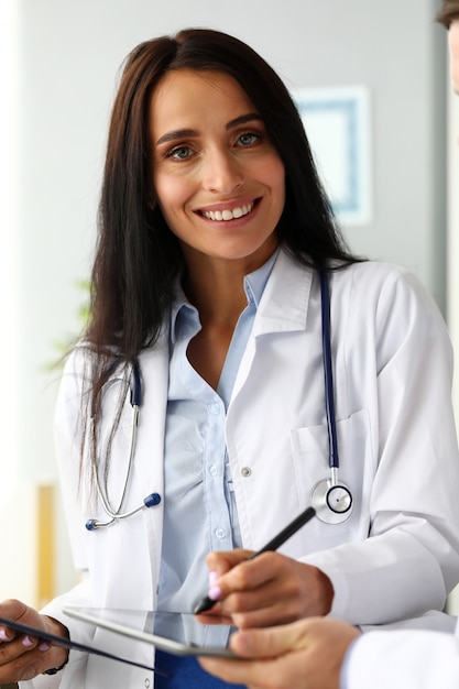 Sorrindo alegre feminino GP fazendo anotações eletrônicas