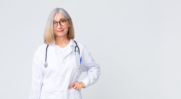 sorrindo alegremente com uma mão no quadril e atitude confiante, positiva, orgulhosa e amigável