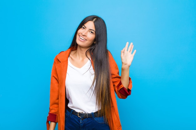 Foto sorrindo alegremente e alegremente, acenando com a mão, dando as boas-vindas e cumprimentando-o ou dizendo adeus