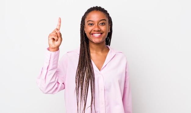 Sorrindo alegremente e alegremente apontando para cima com uma mão para copiar o espaço