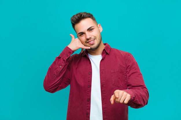 sorrindo alegremente e apontando para a câmera enquanto faz uma ligação, você gesticula mais tarde, falando no telefone