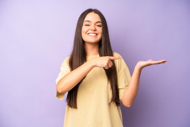 Sorrindo alegremente e apontando para copiar o espaço na palma da mão mostrando ou anunciando um objeto